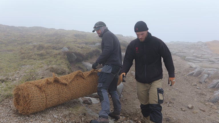 Mournes Rangers unwrapping Geo-Textile Roll on Donard